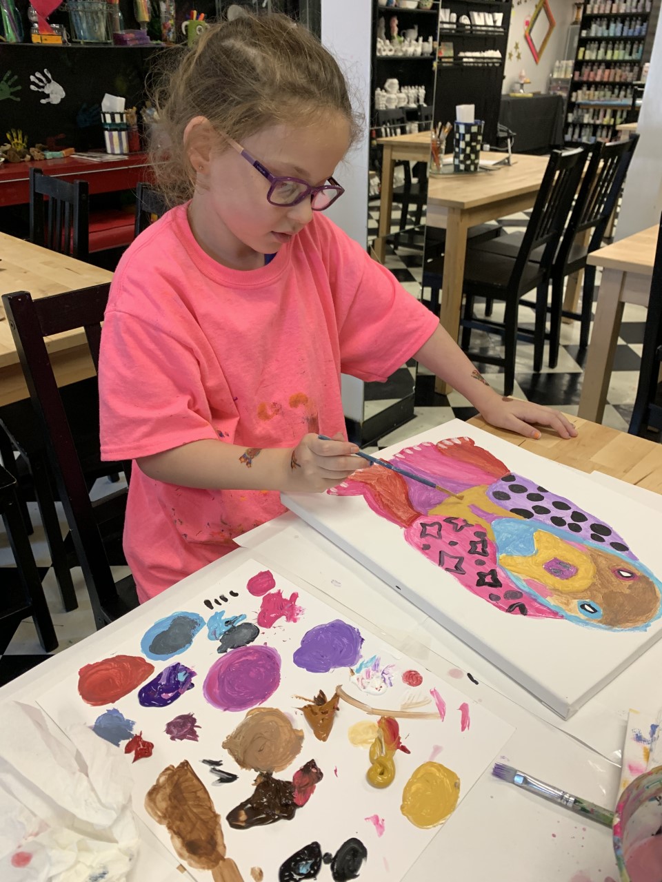 Kid enthusiastically participating in a fun mosaic art class in Englewood NJ